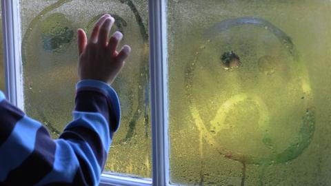 Boy next to window.