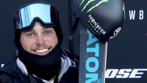A close-up of Gus Kenworthy broadly smiling while wearing skiing gear