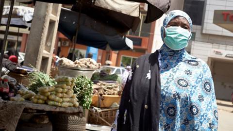 A market seller wearing a mask