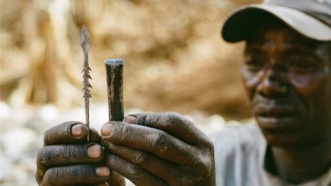 A Hadza man makes an arrowhead