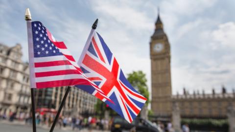 UK and US flags in front of the Houses of Parliament