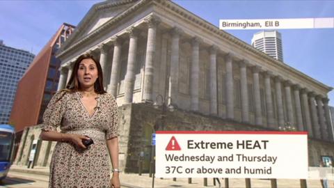A woman in a patterned dress and long brown hair stood in front of a photo of birmingham town hall with an extreme heat weather graphic