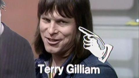 Terry Gilliam, with a white graphic of a hand pointing at his face