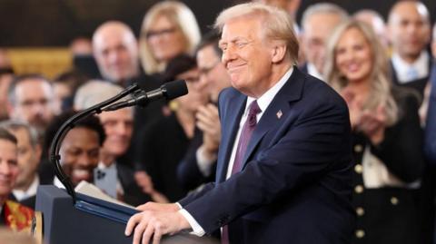 Donald Trump smiles at the podium during the inauguration ceremony