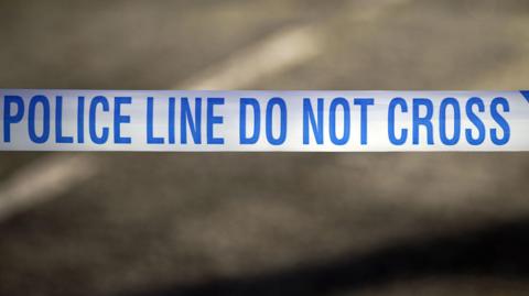 Blue and white "Police Line Do Not Cross" crime scene cordon tape.