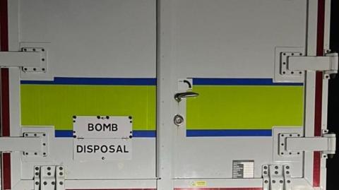 The back of a van which says BOMB DISPOSAL on it.