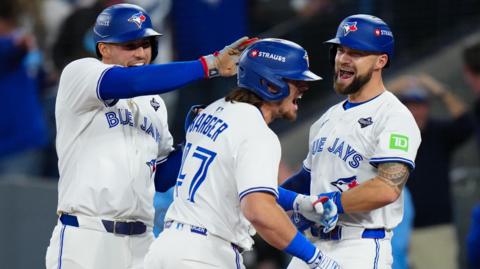 Addison Barger (centre) is congratulated by Toronto Blue Jays team-mates George Springer and Nathan Lukes after hitting his grand slam