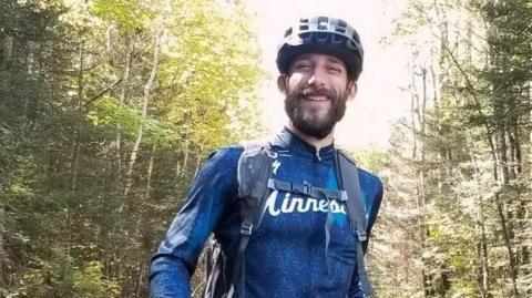 Alex Pretti in cycling gear in what appears to be a wood