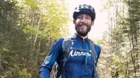 Alex Pretti in cycling gear in what appears to be a wood