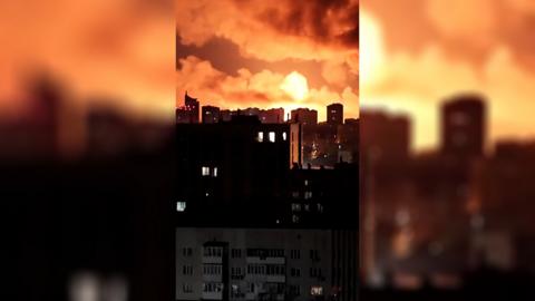 Explosions light the sky orange over a cityscape.