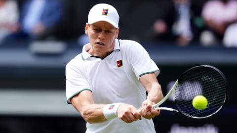 Jannik Sinner hits a backhand