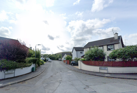 A screengrab of a Google Maps view of Edencreive housing estate in Newry.  There are two-story detached houses with walled gardens on either side of the entrance to the estate.