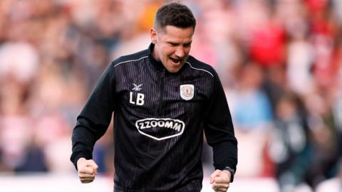 Crewe manager Lee Bell clenches both fists and shouts in celebration