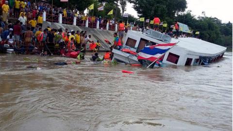 Rescuers work to save people on the stricken boat