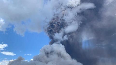 Column of dark ash against blue sky