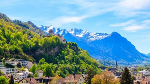 A hilly landscape with houses and mountains.