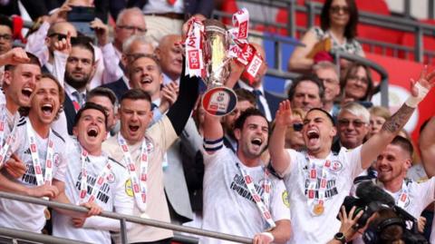 Crawley players lift the League Two play-off final trophy