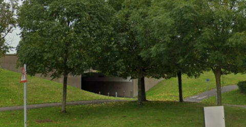 An underpass with grassy verges next to it.