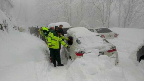 Rescue workers help people escape from their cars