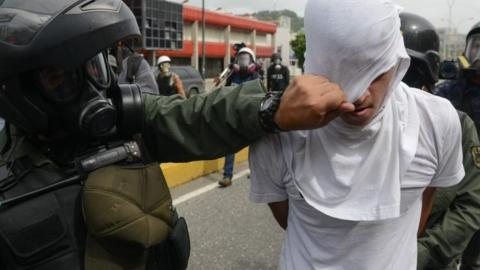 opposition demonstrator is arrested during clashes with riot policemen Caracas on May 22, 2017.