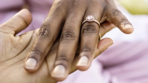 Close-up of a bride hand showing her engagement ring to a friend at bridal shower
