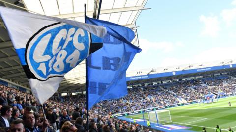 Leicester City fans wage a huge flag at the King Power Stadium