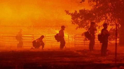 Firefighters look on as the Oak Fire burns in Darrah in Mariposa County, California, U.S. July 22, 2022.
