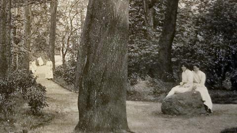 Two girls sit on one of the boulders in 1911.