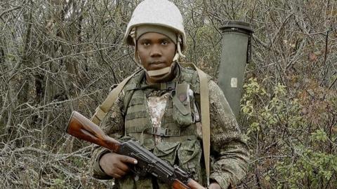 Clinton Nyapara Mogesa, in military uniform, holding a rifle
