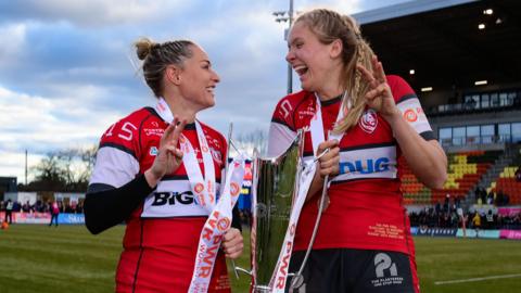 Natasha Hunt and Zoe Stratford (formerly Aldcroft) hold the PWR trophy between them and also three fingers up on each of their hands