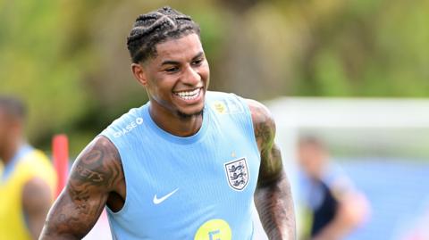 Marcus Rashford smiles during training