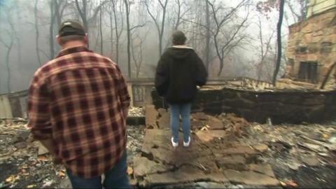 Couple looking at burned out house