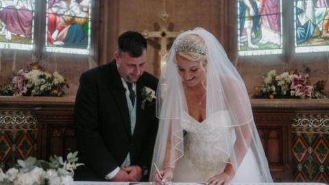 Sophie and John sign their marriage certificate