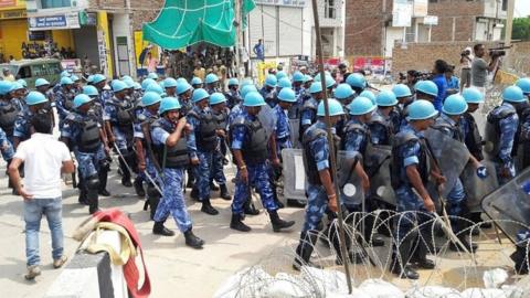 Indian paramilitary personnel walk towards the "Dera Sacha Sauda" Ashram in Sirsa on August 26, 2017