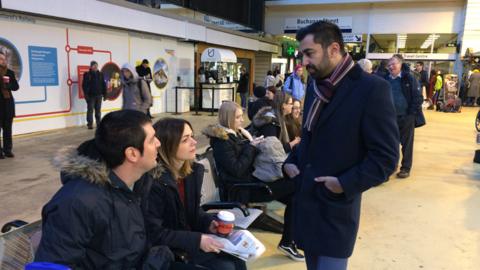 Humza Yousaf talking to passengers