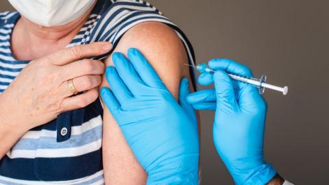 Stock image of a woman receiving a Covid-19 vaccination