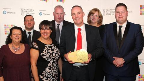 Carlton Bolling College's management team holding a gold trophy