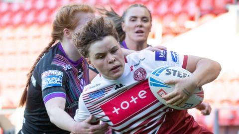 Molly Jones carries the ball for Wigan Warriors