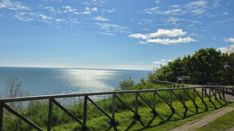 Scenic view of the sea on a bright sunny day from a grassy cliffside vantage point
