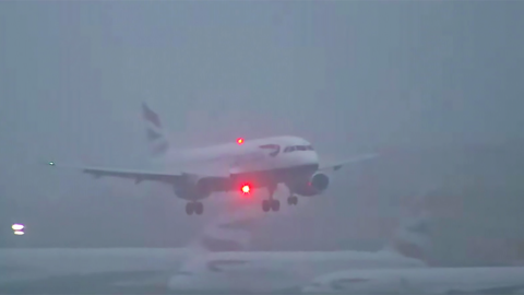 A plane is see landing in thick fog at an airport.