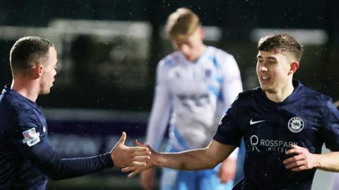 Paul O'Neill (right) celebrates scoring the opener for Larne against Ballymena