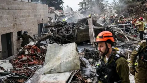Emergency personnel work at the site of an Iranian strike, after Iran launched missile barrages following attacks by the U.S. and Israel on Saturday, in Beit Shemesh