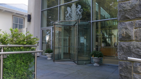 The exterior of the courthouse in Guernsey. It is a glass-fronted building with a revolving door.