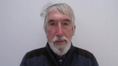 An elderly man with a white beard and white hair.