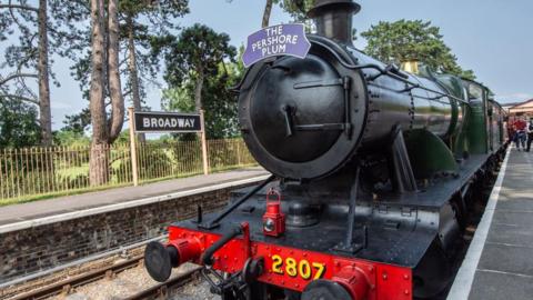 An old fashioned steam train sitting at a station