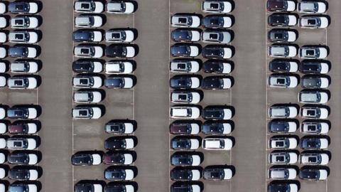 An aerial view of whit and black imported new cars on the quayside of Alexandra Dock at Grimsby Port.
