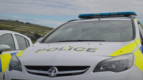 Police car with fields in background