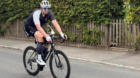 Man in cycling gear and helmet on a bike