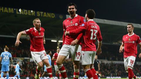 Wrexham striker Kieffer Moore celebrates with Lewis O'Brien and Liberato Cacace 