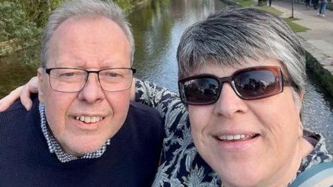 Dawn D'Auvin is pictured with her arms around her husband during a walk along a canal